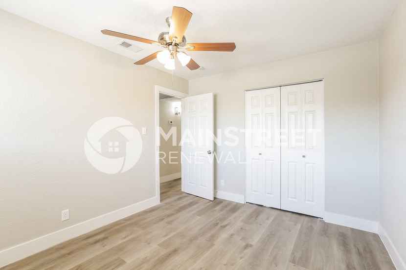 a bedroom with a ceiling fan and a closet