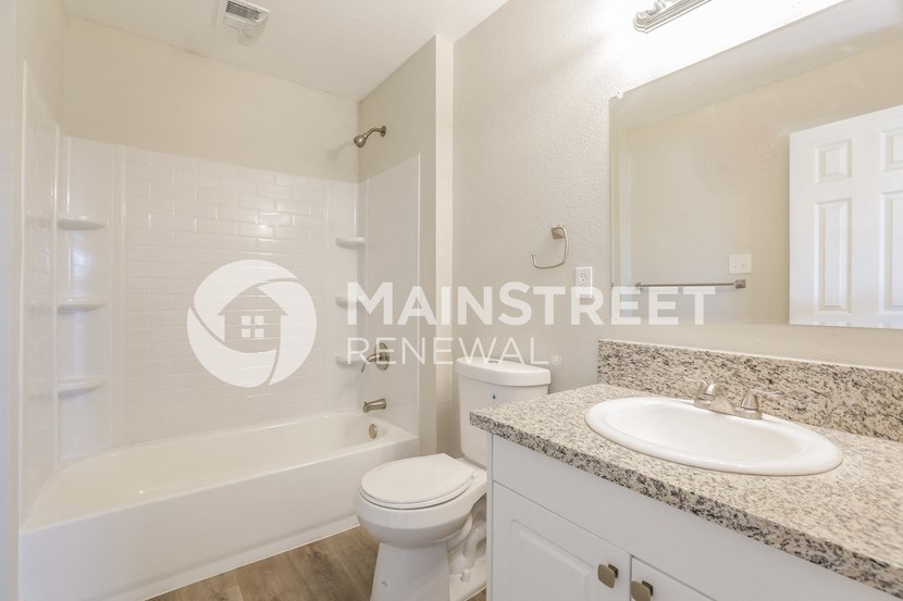 a bathroom with a sink and a toilet and a bath tub