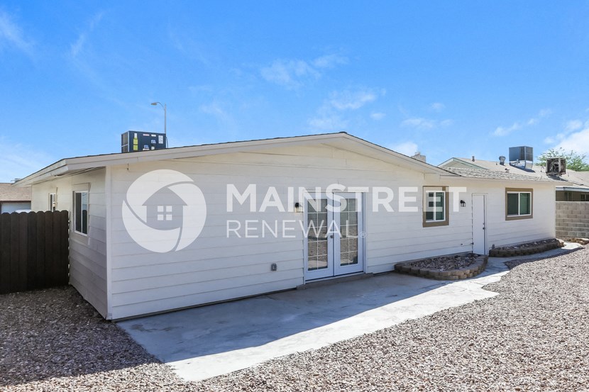 a small white house with a garage and a driveway