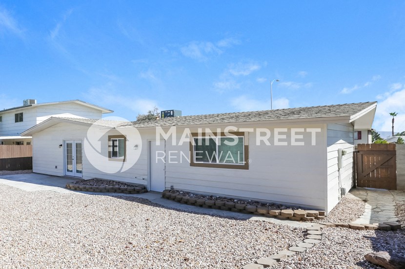 a small house with a garage and a sign on the side of it