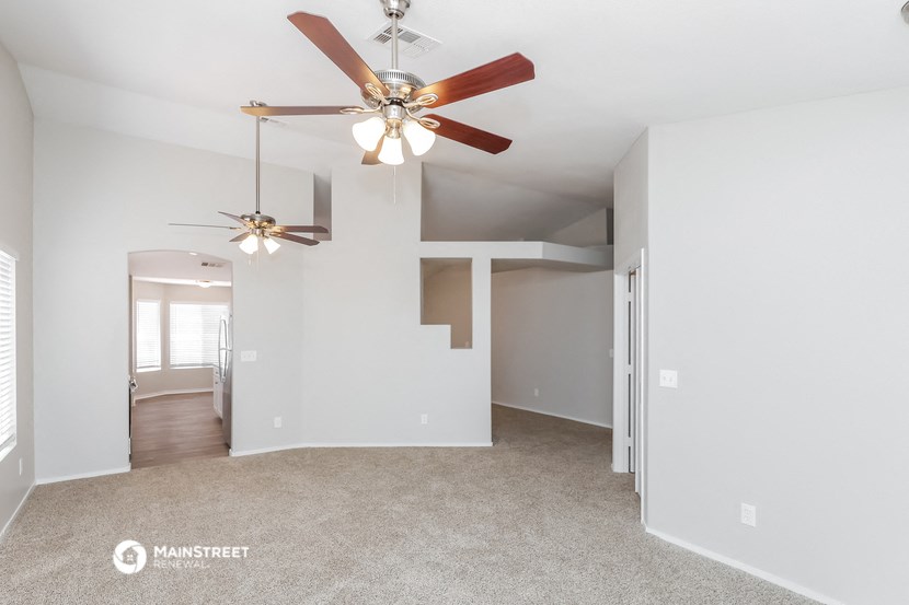 the living room and dining room with ceiling fans