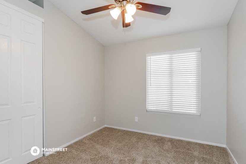 the bedroom has a ceiling fan and a closet