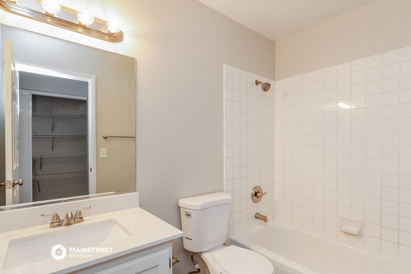 a bathroom with a toilet sink and tub and a mirror