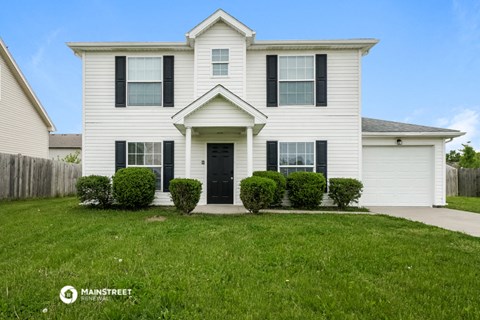 a white house with black shutters and a lawn