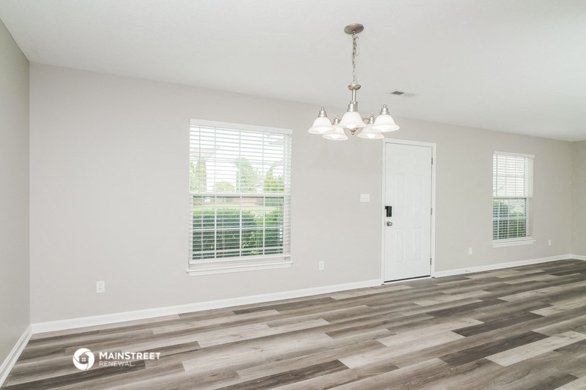 the living room of a new home with a large window and a door