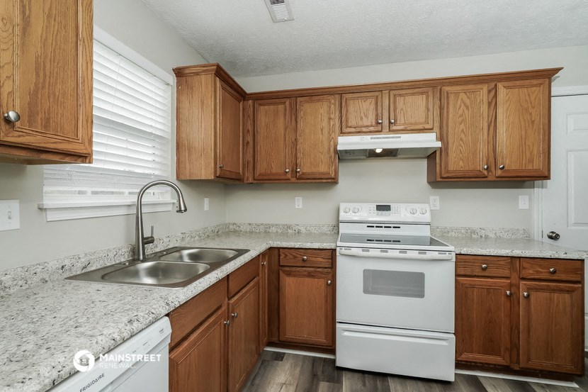 a kitchen with wooden cabinets and white appliances and granite counter tops