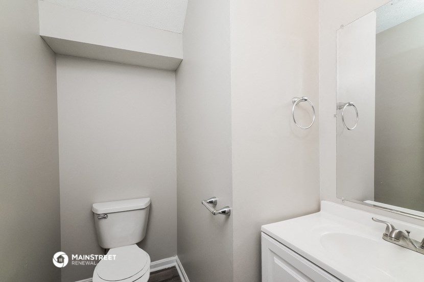 a bathroom with a toilet and a sink and a mirror