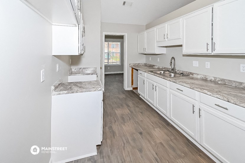 a white kitchen with marble counter tops and white cabinets