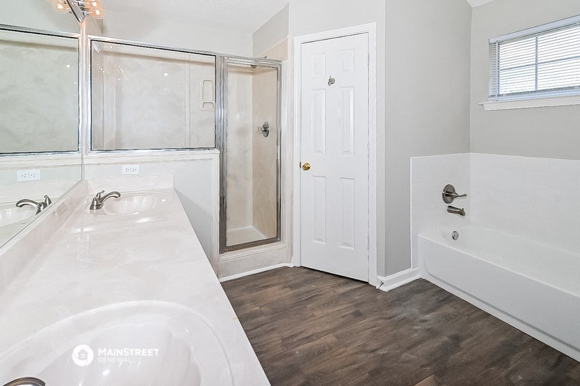 a bathroom with a tub and a shower and a sink