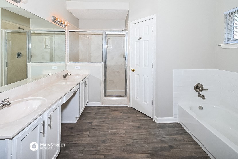 a bathroom with a tub and a sink and a shower