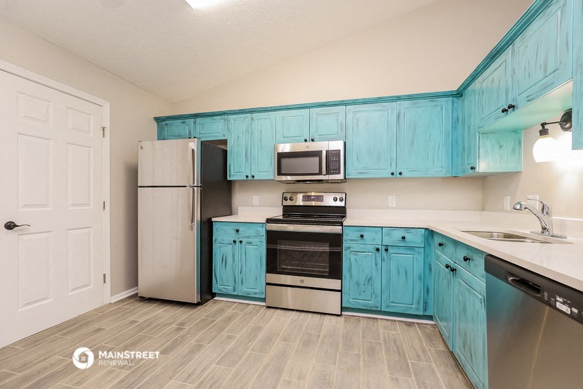 a kitchen with blue cabinets and stainless steel appliances