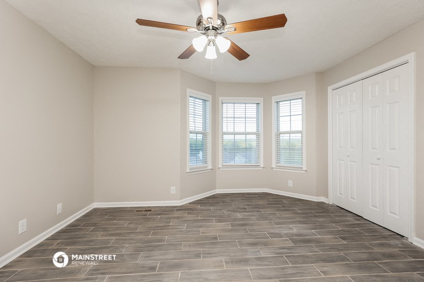 the spacious living room with tile flooring and a ceiling fan