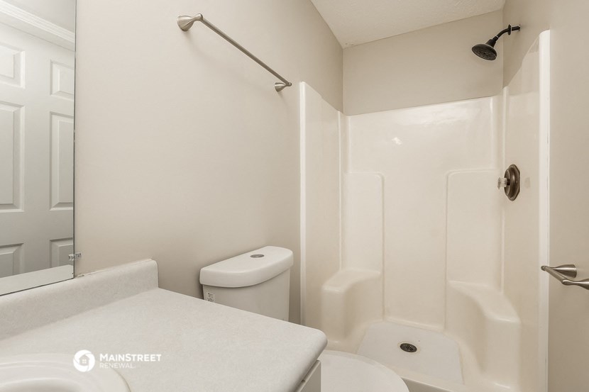 a white bathroom with a shower toilet and sink