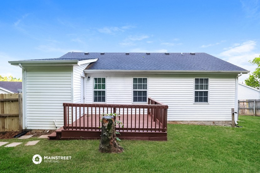 a deck in the backyard of a white house