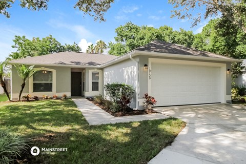 a white house with a lawn and a driveway