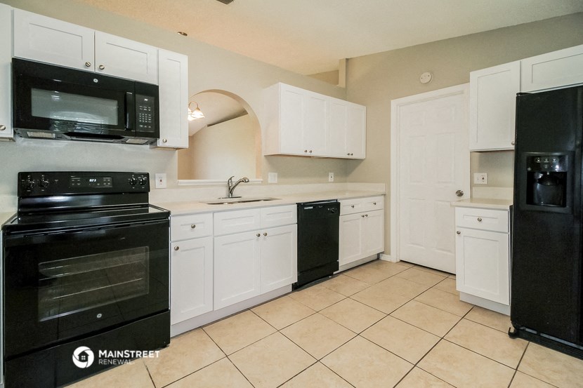a kitchen with black appliances and white cabinets