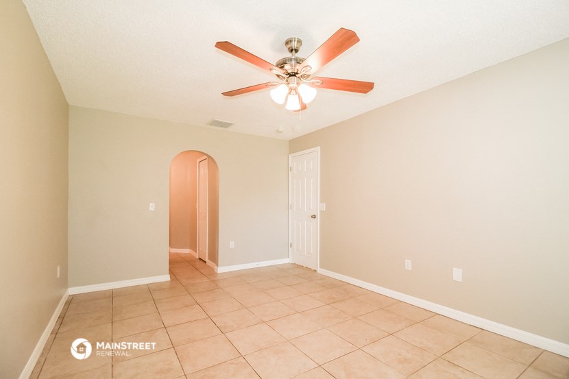 the living room has a ceiling fan and a tiled floor