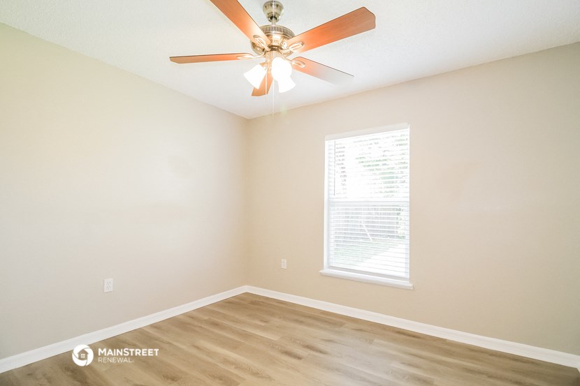 a bedroom with a ceiling fan and a window