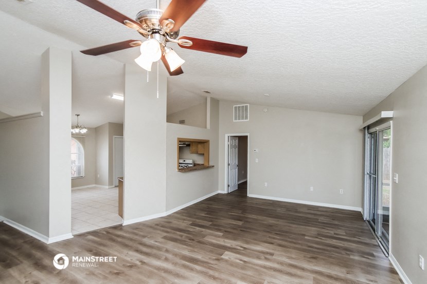 a spacious living room with a ceiling fan