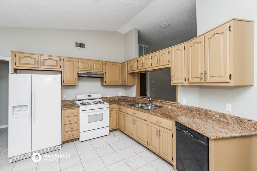 a kitchen with wooden cabinets and white appliances and granite counter tops