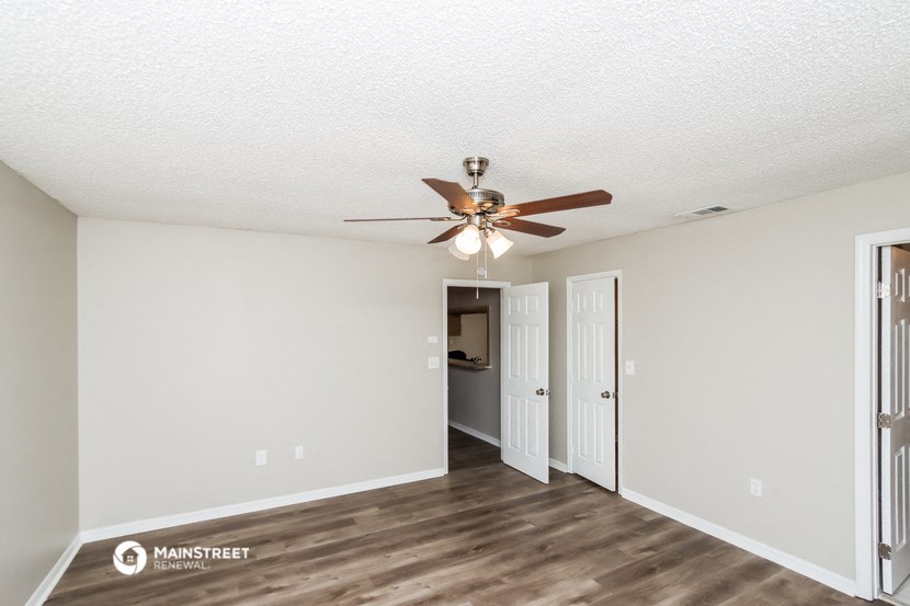 the living room of our two bedroom apartment atrium with ceiling fan and closet