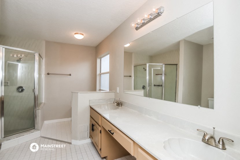 a bathroom with a large mirror and a sink and a shower