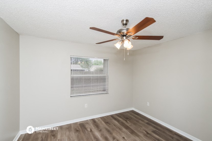 the spacious living room of our studio apartment atrium with ceiling fan and window