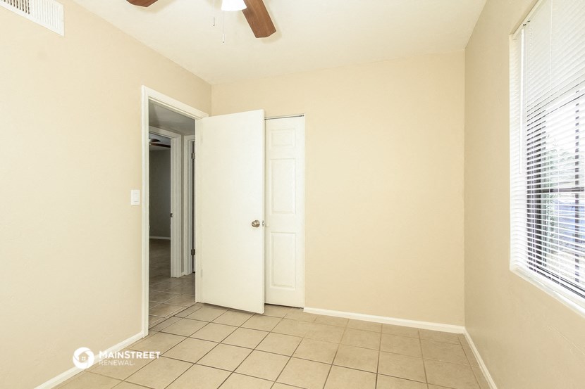 a hallway with a door to a closet and a door into a room