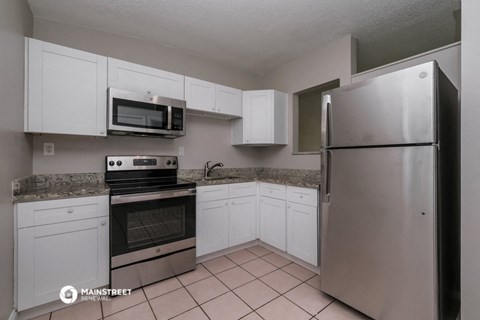 a kitchen with white cabinets and stainless steel appliances