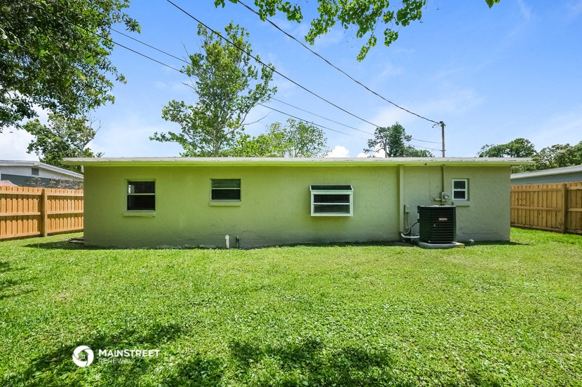 a small green house with a yard and a fence