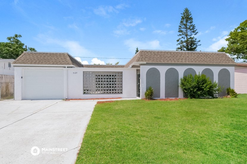 a white house with a driveway and a lawn