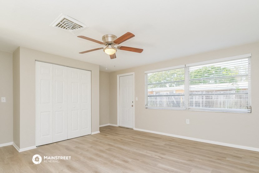 a living room with a ceiling fan and a window