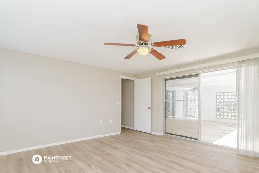 a living room with a ceiling fan and a sliding glass door