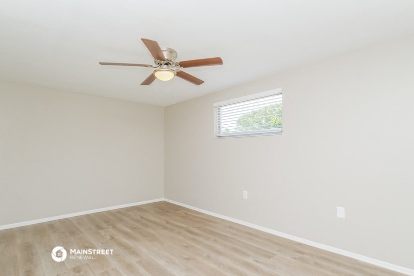 a bedroom with a ceiling fan and a window