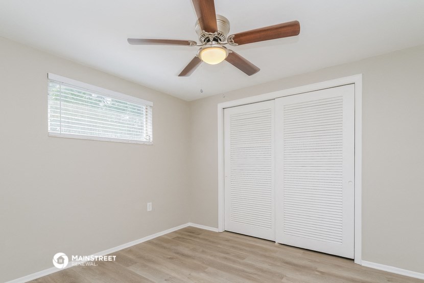 the living room has a ceiling fan and a large closet