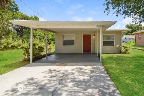 a covered porch with a driveway in front of a house