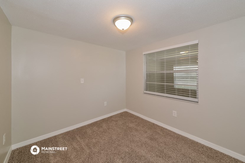 the upstairs bedroom has carpet and a large window