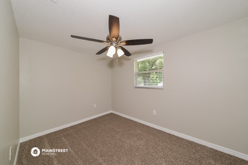 the bedroom has a ceiling fan and a window