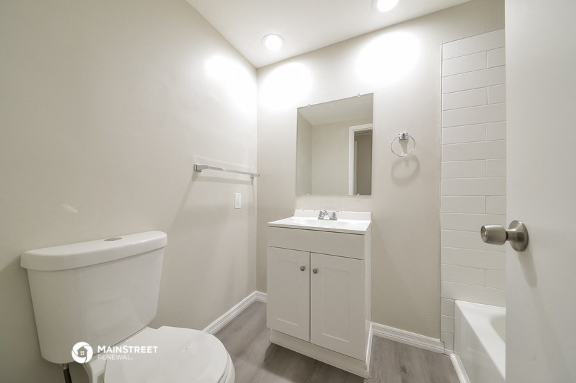 a white bathroom with a toilet sink and shower