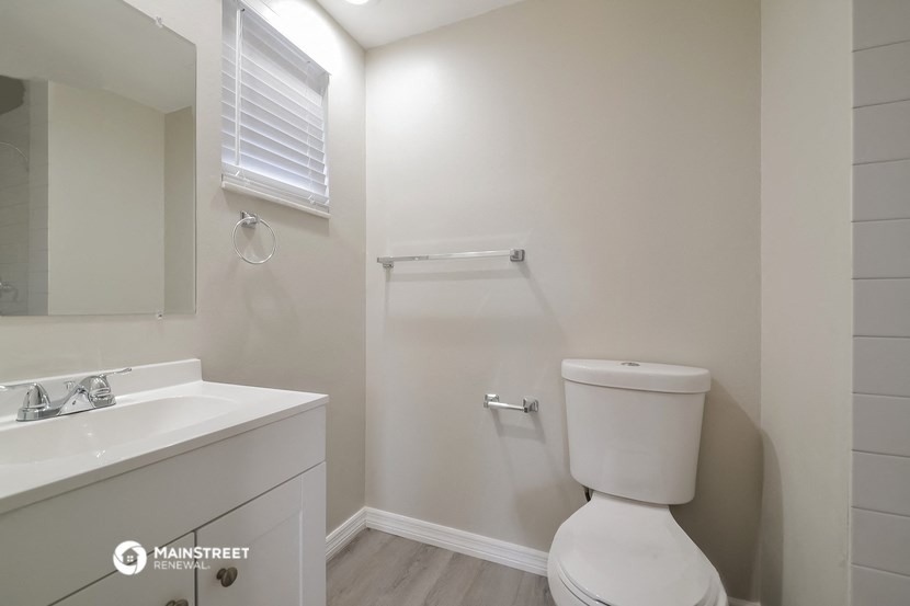a white bathroom with a toilet and a sink