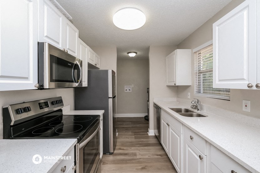 a kitchen with white cabinets and stainless steel appliances