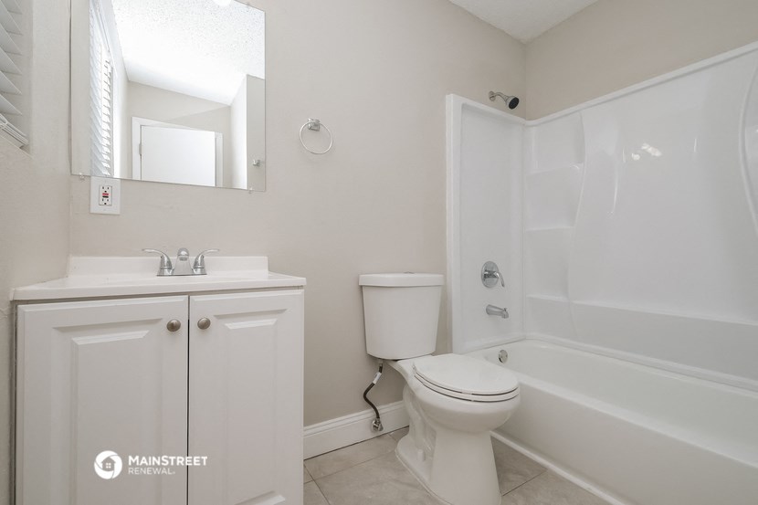 a bathroom with a toilet and a sink and a bath tub