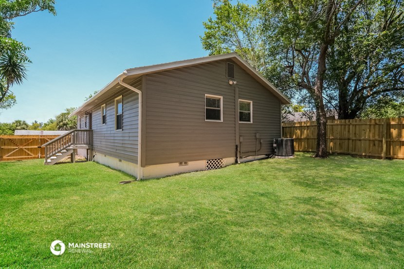 a small house in a backyard with a yard and a fence