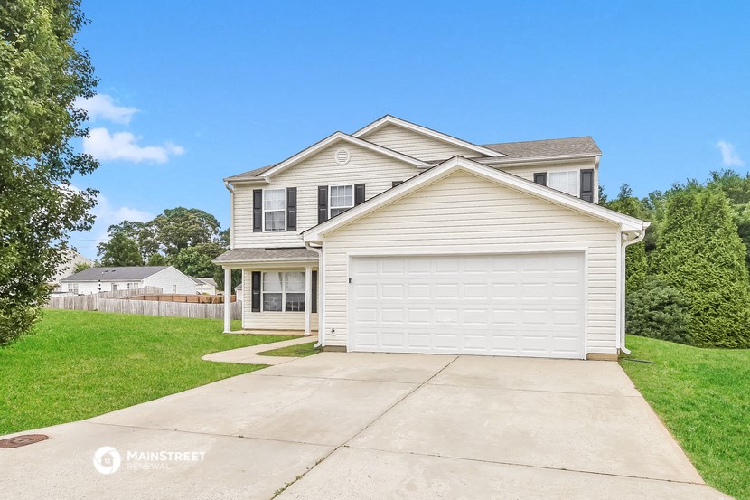 a white house with a driveway and a white garage door