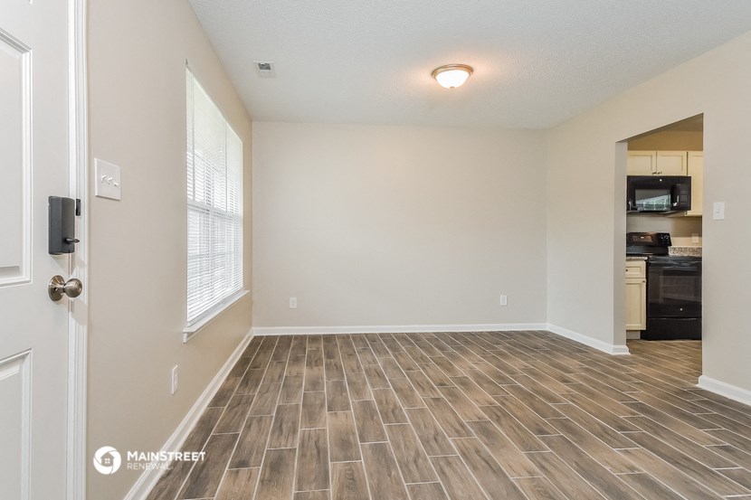 the spacious living room with wood flooring and an open kitchen