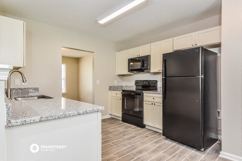 a kitchen with stainless steel appliances and a marble counter top