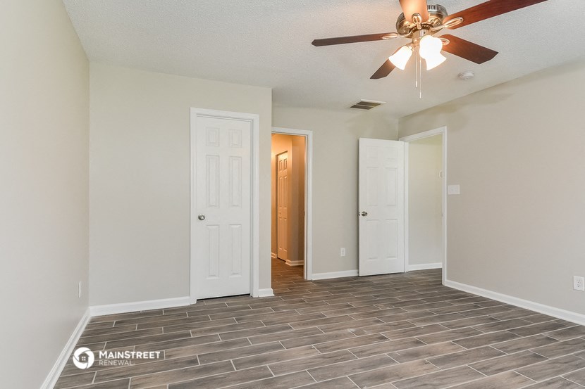 the living room of an empty house with a ceiling fan