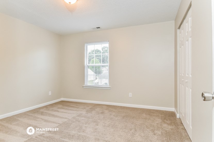 an empty room with a window and a door