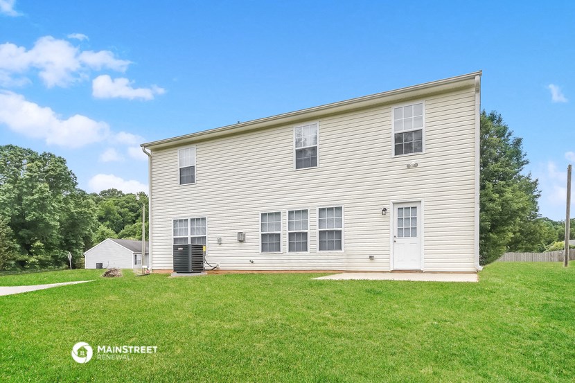 a white house with white siding and a green lawn