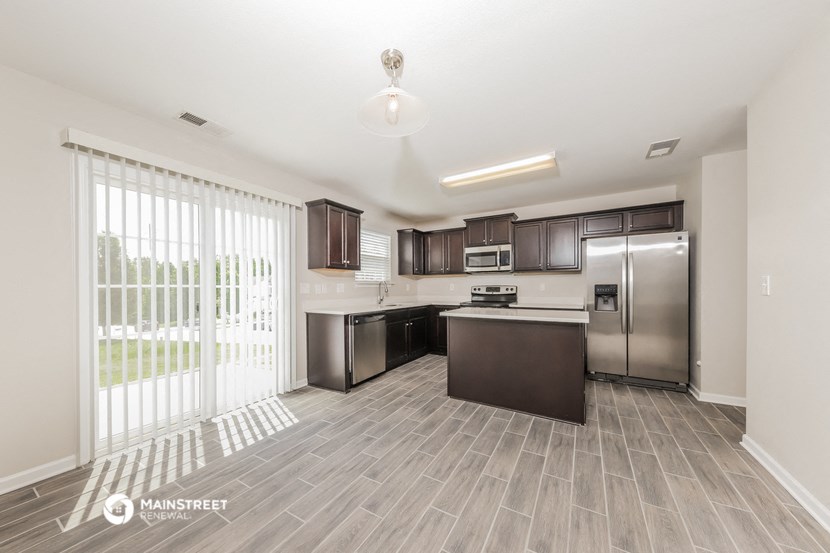 a spacious kitchen with stainless steel appliances and a large window
